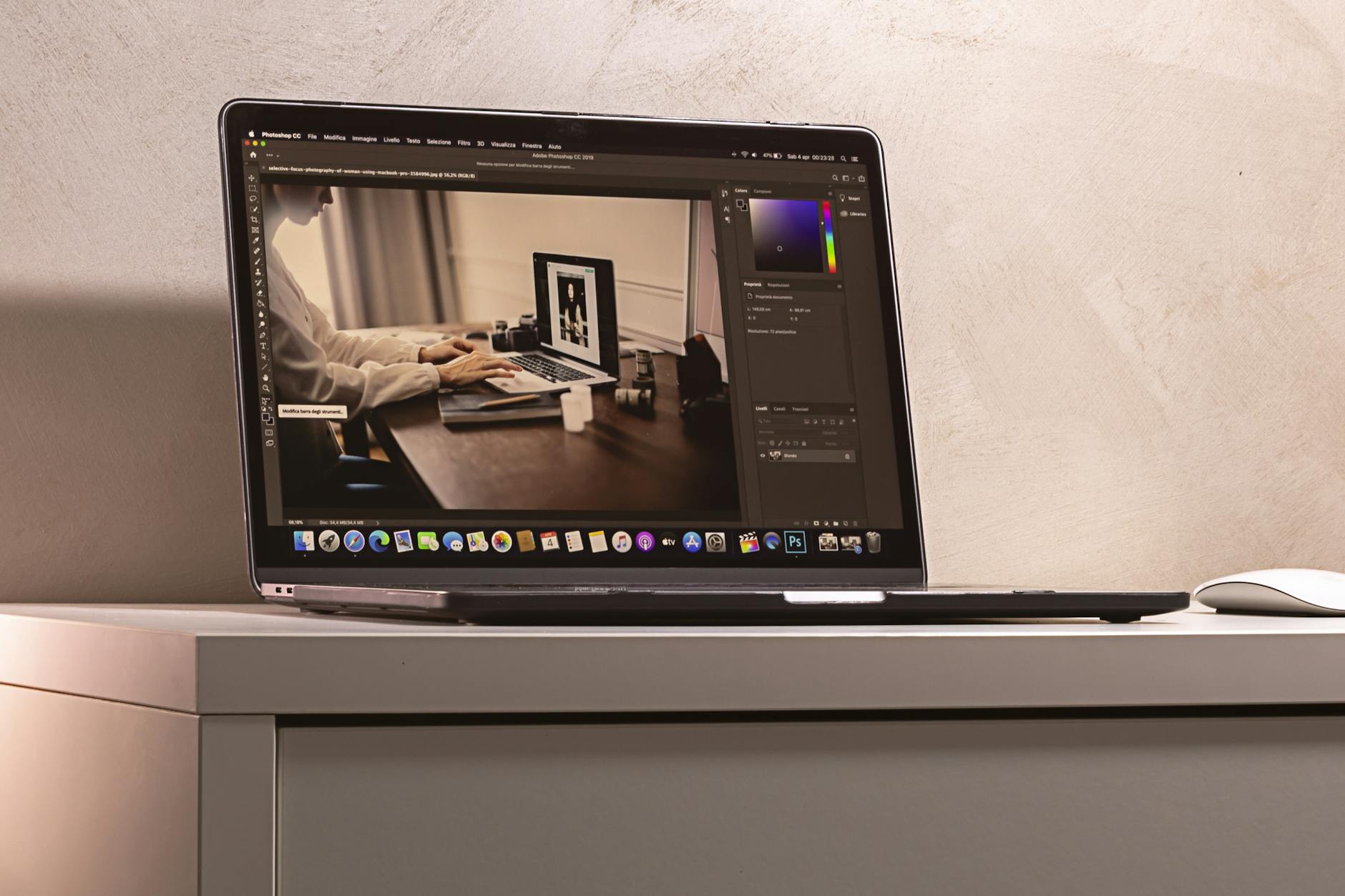 A laptop displaying a photo editing software interface on a clean, modern desk setup.