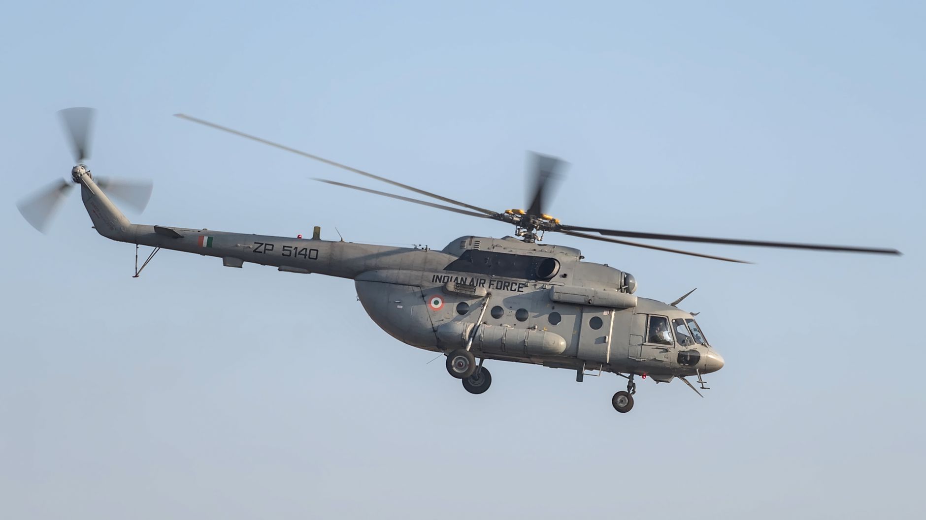 A gray Indian Air Force helicopter flying during an airshow in Bengaluru, India.