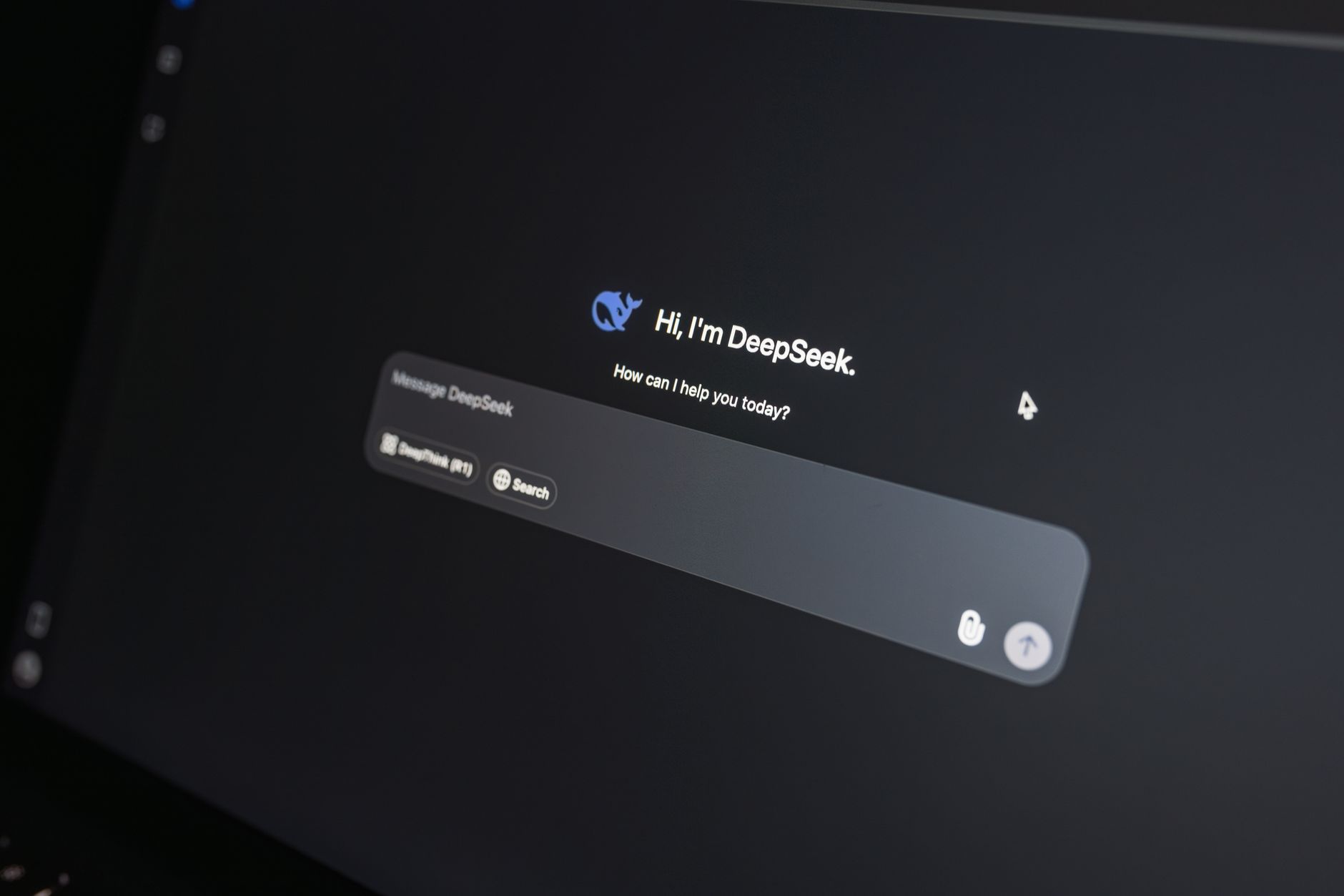 Close-up of DeepSeek AI chat interface on a laptop screen in low light.